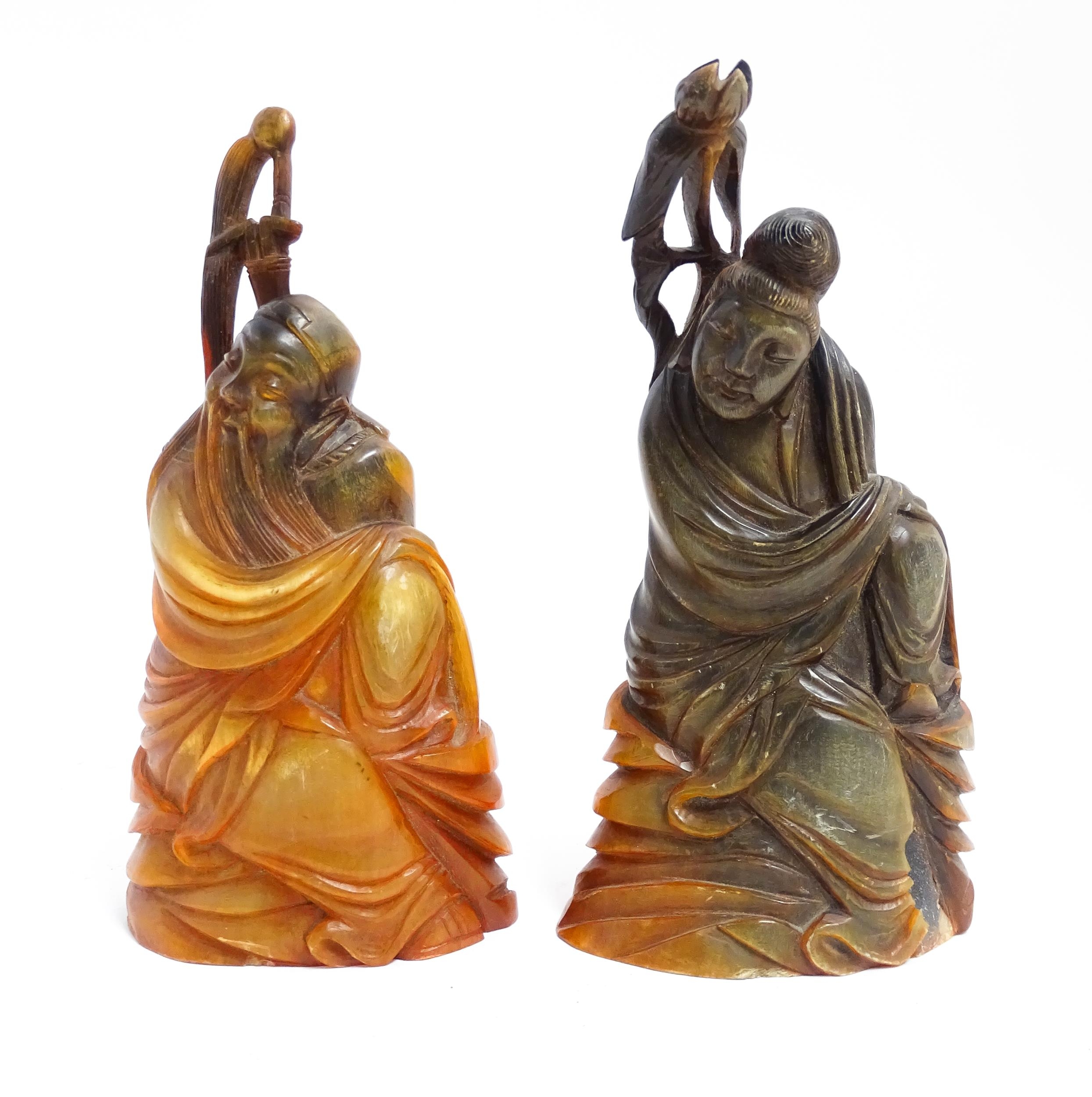 Two Chinese horn carvings depicting a sage figure and a deity figure. Largest approx. 6 1/4" high (