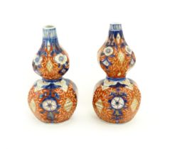 A matched pair of Japanese double gourd vases decorated in the Imari palette with floral motifs
