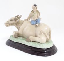 A Chinese model of a young boy riding a water buffalo. Approx. 7 1/4" high overall Please Note -