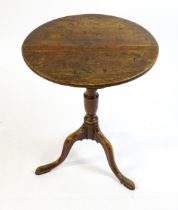 A late 18thC oak tripod table with a circular top above a tapering turned pedestal and three