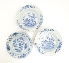Three Chinese blue and white plates / dishes, two decorated with peony flowers, the other