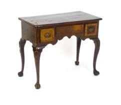 An 18thC walnut low boy with a moulded and cross banded top above three short drawers with a
