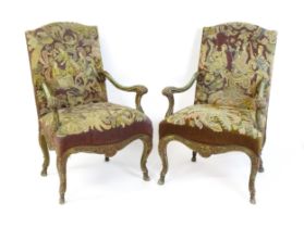 A pair of 20thC open armchairs, with shaped top rails, shaped arms with carved and scrolled