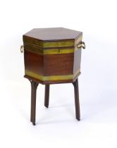 A late 18thC / early 19thC mahogany wine cooler of hexagonal form, with brass strapwork and