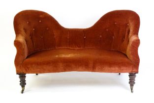 A late 19thC hump back / camel back sofa with deep buttoned upholstery and sprung seat, the sofa