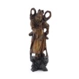 A Chinese carved wooden model of a standing figure with a sword. Approx. 16" high Please Note - we