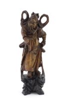 A Chinese carved wooden model of a standing figure with a sword. Approx. 16" high Please Note - we