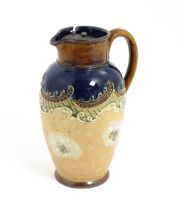 A Royal Doulton Slater stoneware jug with floral and scrolling detail with a pewter lid, designed by