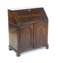 A mid 18thC oak bureau with a sloped fall front, opening to show fitted drawer and pigeon hole
