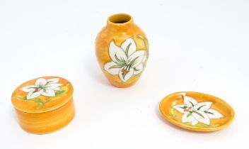 Three items of Moorcroft decorated in the Bermuda Lily pattern comprising small vase, pin dish and