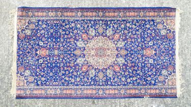 Carpet / Rug : A blue ground rug with central roundel motiff and floral and foliate detail.