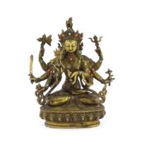 A Tibetan cast bronze figure of Guanyin with eight arms holding various symbols to include ruyi,