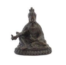 A Tibetan cast bronze model of the Buddhist master Padmasambhava / Guru Rinpoche seated holding