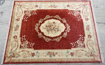 Carpet / Rug : A red ground rug with central floral vignette and garland with foliate detail with