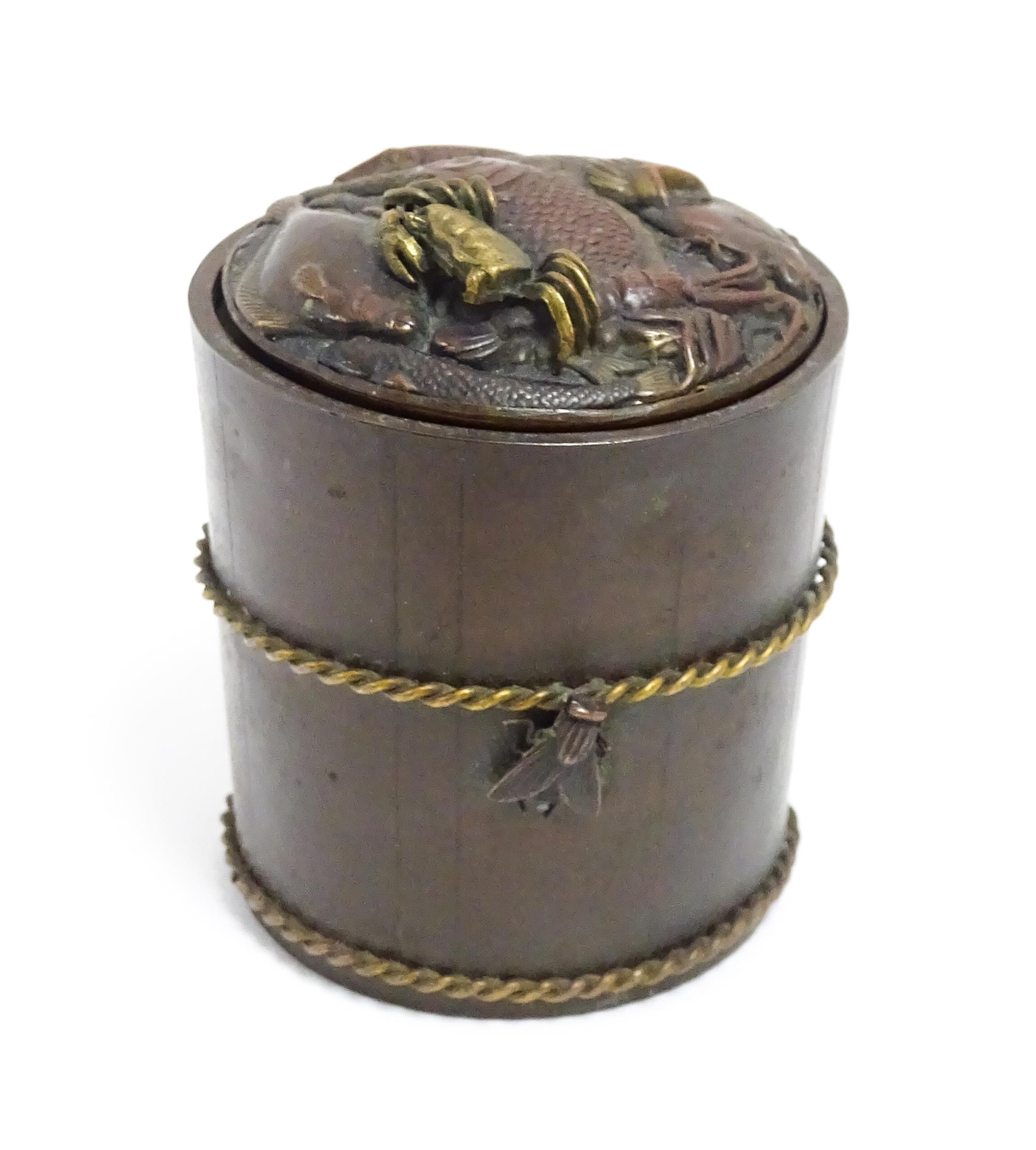 A Japanese bronze novelty inkwell of cylindrical form, the lid with fish and crab detail, the body