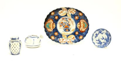 Four assorted Oriental items comprising a Japanese dish of oval form decorated in the Imari