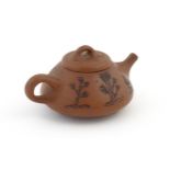 A Chinese Yixing teapot with incised tree and script detail. Character marks under and to