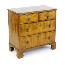 An 18thC walnut chest of drawers with a moulded and crossbanded top above two short over three