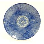 A Japanese blue and white plate with central floral motif bordered by bands of patterned detail