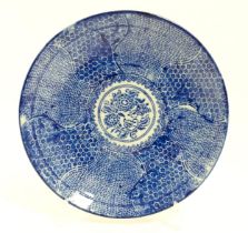 A Japanese blue and white plate with central floral motif bordered by bands of patterned detail