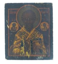 A 19thC Russian tempera on card laid on wooden panel icon depicting St. Nicholas of Myra flanked