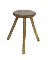 A 19thC primitive stool of large proportions, the octagonal top raised on three legs. 24" high x 14"