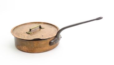 A large Continental copper saute pan with cast iron handle, the cover with a brass handle. Stamped