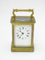 An early 20thC French brass carriage clock with white enamel dial with Roman Numerals. The