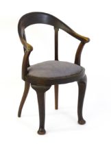 An early 20thC bow back armchair, with a shaped and bowed top rail above a circular seat and