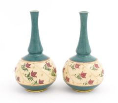 A pair Royal Doulton bottle vases with turquoise ground and banded pink rose detail. Marked under.