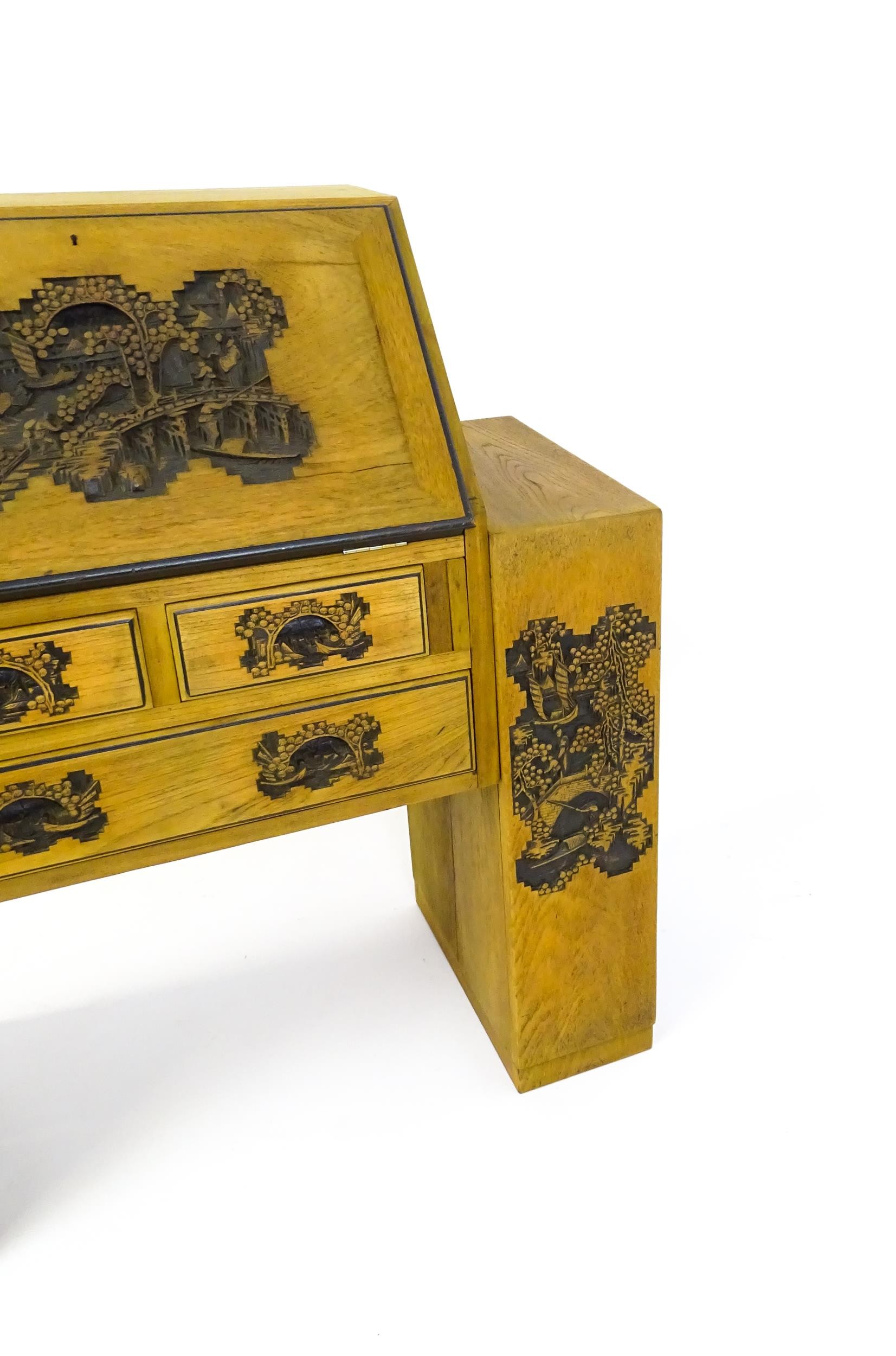 An early / mid 20thC Teak bureau accompanied by a stool, with carved oriental scenes to the front, - Image 4 of 12