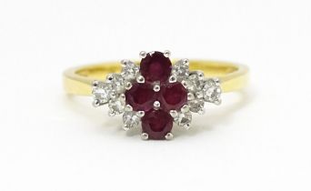 An 18ct gold ring set with four rubies bordered by diamonds. Ring size approx. M Please Note - we do