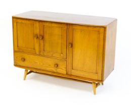 Vintage / Retro: An Ercol elm sideboard (model 366), the figured elm top above three panelled
