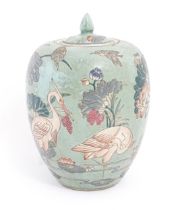 A Chinese ginger jar with celadon style glaze decorated with crane birds, flowers, lily pads, etc.