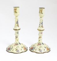 Two Bilston / Battersea enamel candlesticks with knopped columns and domed bases with hand