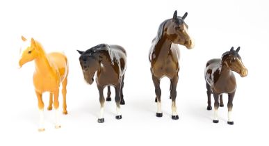 Four Beswick models of horses comprising to include a brown mare, a palomino, and two brown