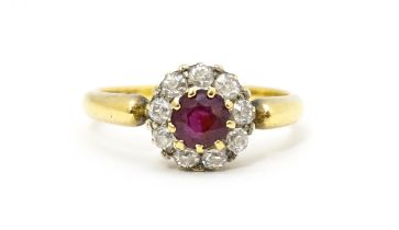 An 18ct gold ring set with central ruby bordered by diamonds. Ring size approx. O 1/2 Please