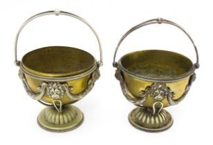 A pair of brass and silver plate pedestal bowls with lions mask and swag detail and swing handles.