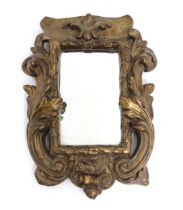 A late 19th / early 20thC carved giltwood and gesso framed mirror with acanthus leaf and scroll