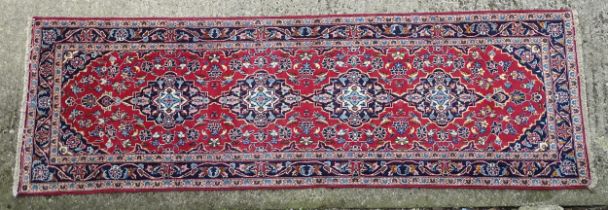 Carpet / Rug: A Central Persian kashan runner, the red ground with blue and cream ground motifs,