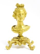 A small 19thC gilt bronze bust of a lady with a ribbon in her hair, on a scrolled gilt base. Approx.