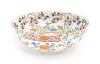 A Chinese bowl decorated with stylised pine trees, flowers and foliage, with banded borders. Approx.