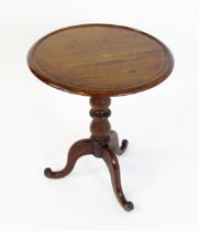 A Victorian mahogany tripod table with a circular dished top above a turned pedestal and three