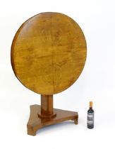 A 19thC walnut tilt top table of unusual proportions, with a circular table top above a canted