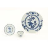 A Chinese Nanking Cargo blue and white tea bowl and saucer decorated with pine trees and banded