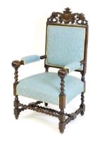 A large 19thC armchair with a carved and pierced cresting rail, with an armorial shield set within