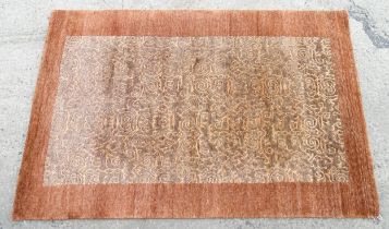 Carpet / Rug : A Nepalese woollen hand knotted rug worked in terracotta, taupe and beige. Approx.
