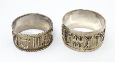 Two Continental silver napkin rings both decorated with astrological symbols. One with rope twist