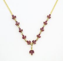 An 18ct gold necklace set with 33 rubies and 10 diamonds. Approx 17" long Please Note - we do not