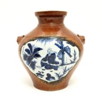 A large Chinese vase with red ground twin animal mask handles, and blue and white panelled
